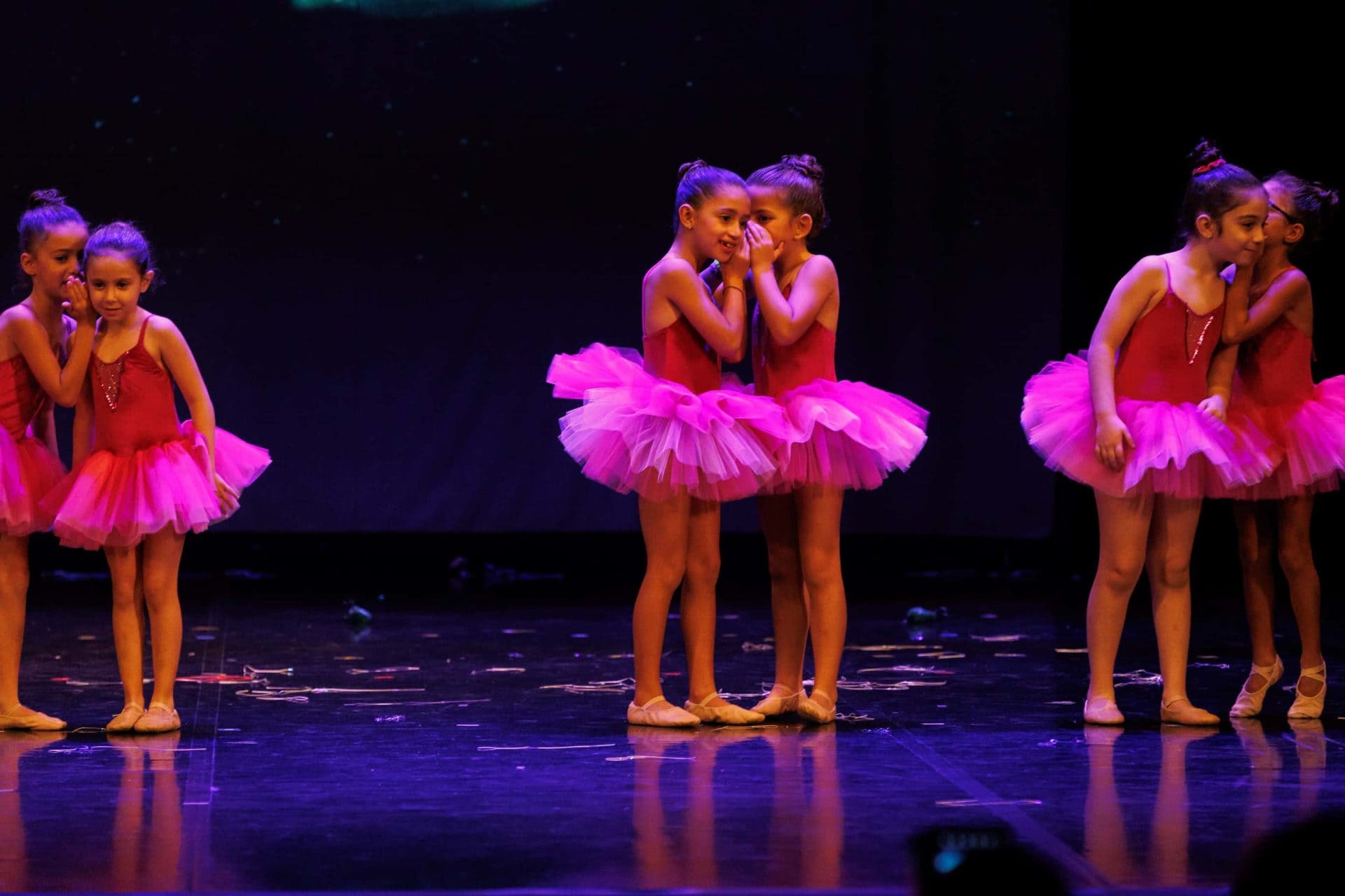 beautiful young ballerinas whispering to each other in a show on stage
